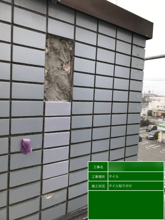 Fマンション 外壁の補修箇所へ新しいグレー系タイルを下側から張り付けた工程
