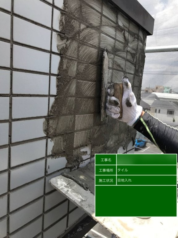 東京都足立区南花畑 Fマンション 外壁タイル張替え後に目地材を充填している作業風景